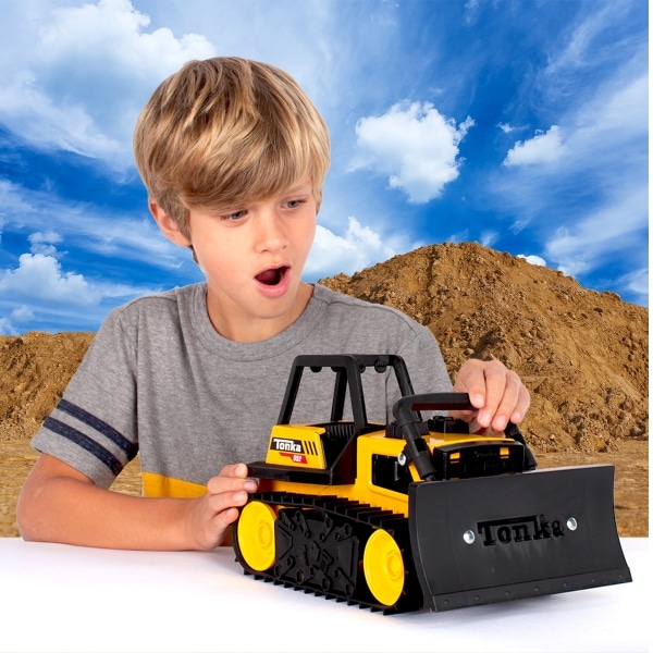 Young boy looking down at Tonka Bulldozer.