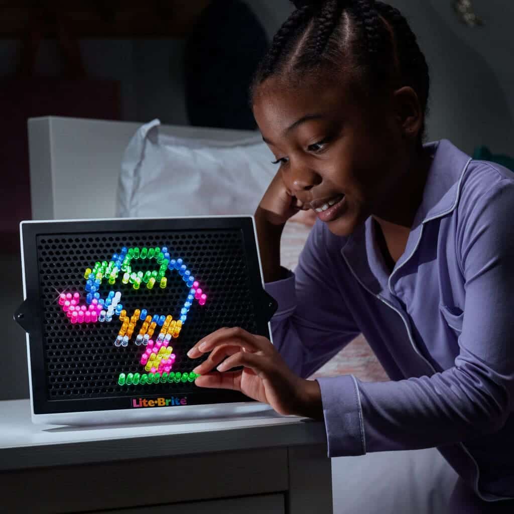 Young girl playing with Lite Brite Classic.