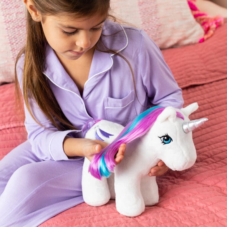Girl with white plush unicorn with purple hair