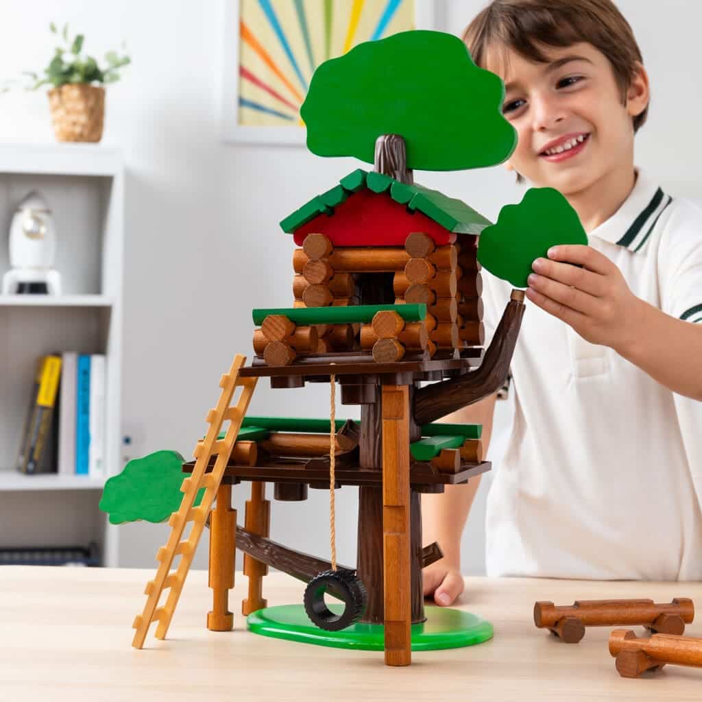 Young boy playing with Lincoln Logs Treehouse.